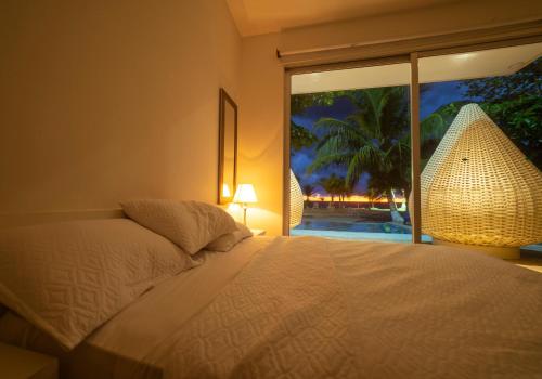 a bedroom with a bed and a large window at Quinta del Mar La Joya in Tolú