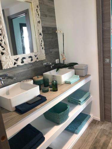 ein Badezimmer mit zwei Waschbecken und einem Spiegel auf einem Regal in der Unterkunft Villa Marina in Sanary-sur-Mer