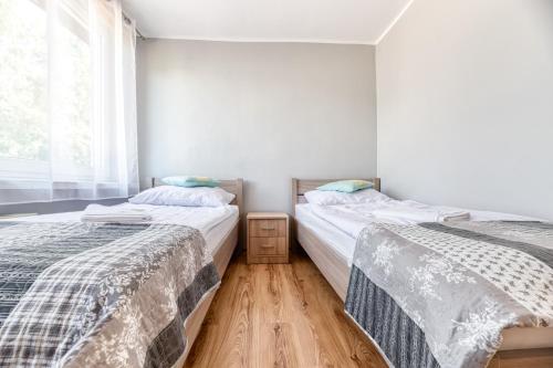 dos camas sentadas una al lado de la otra en una habitación en Apartament Arturro z ogródkiem en Szklarska Poręba