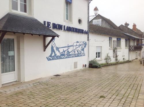 a building with a mural on the side of it at Hotel Le Bon Laboureur in La Charité-sur-Loire
