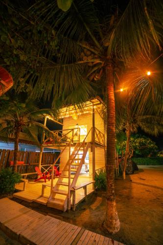 a house with a staircase and palm trees at night at Quinta del Mar La Joya in Tolú