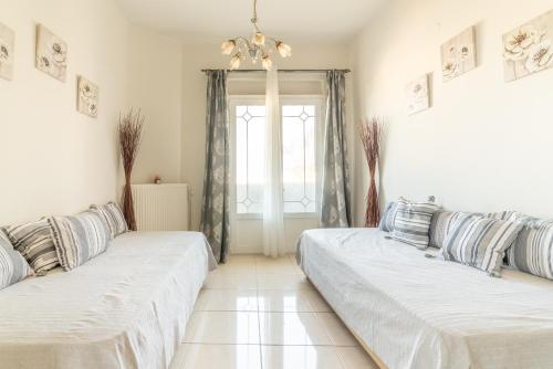 two beds in a room with a window at Coastal Family House With SeaView in Heraklio Town