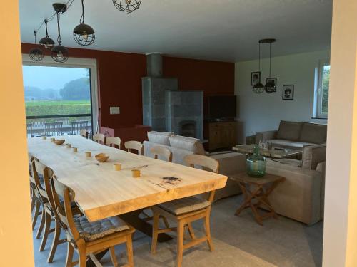 a living room with a large wooden table and chairs at Maison mystique in Staden