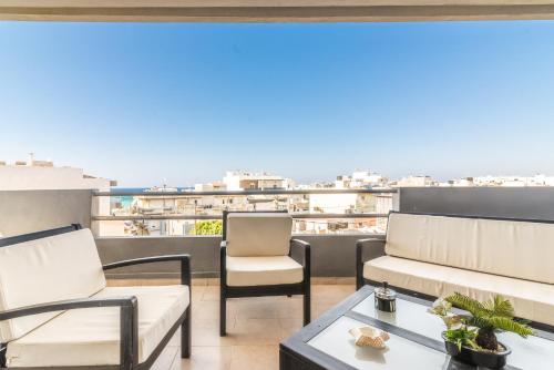 a balcony with furniture and a view of the city at Coastal Family House With SeaView in Heraklio Town