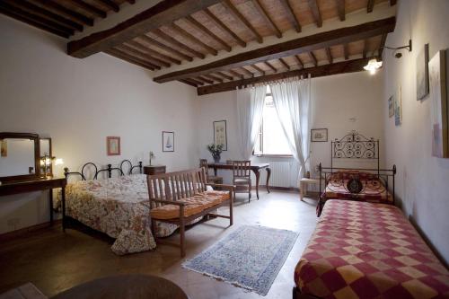 Schlafzimmer mit einem Bett, einem Tisch und Stühlen in der Unterkunft Gli Angeli in Sarteano