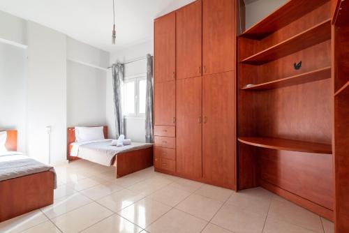 a bedroom with a bed and a large wooden cabinet at Coastal Family House With SeaView in Heraklio Town