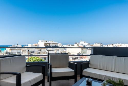 two chairs and a table on a balcony with a view at Coastal Family House With SeaView in Heraklio Town