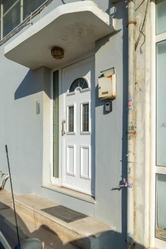 a white door on the side of a building at Coastal Family House With SeaView in Heraklio Town