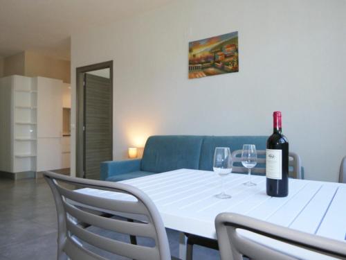 a table with a bottle of wine and two wine glasses at Residence Casa Di Caccia in Marina di Bibbona