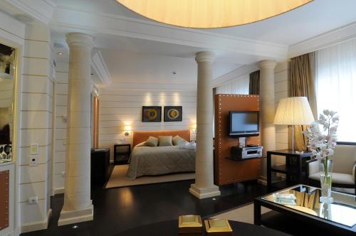 a bedroom with a bed and a living room at Club Hotel Casino Loutraki in Loutraki