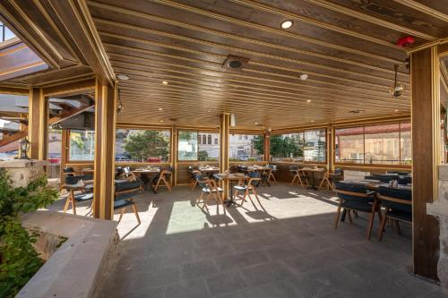 a restaurant with wooden ceilings and tables and chairs at Foremanson Cave Hotel in Nar