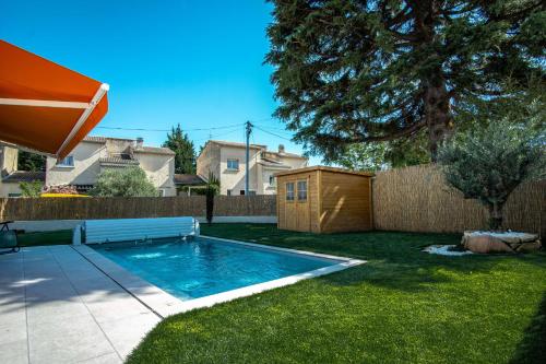 una piscina en un patio con una valla en Le Cabanon de Christine, en LʼIsle-sur-la-Sorgue