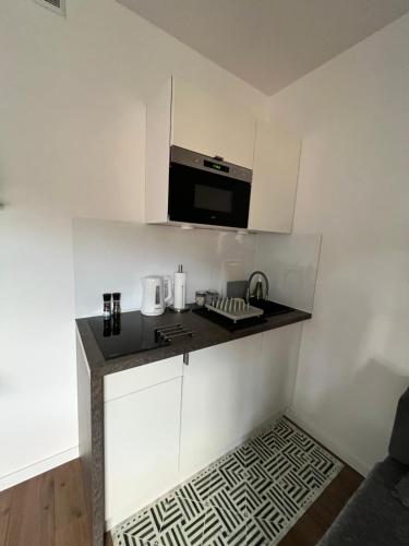 una pequeña cocina con fregadero y microondas en Apartament Love Góry Karpacz Centrum, en Karpacz