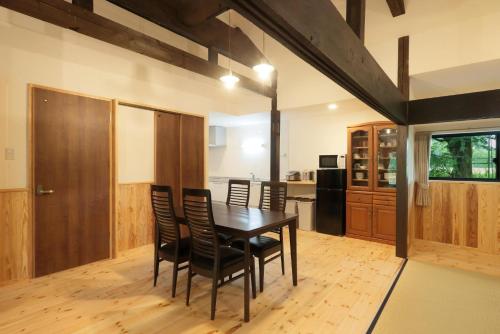 uma sala de jantar com uma mesa de madeira e cadeiras em Cottage Kugino - Vacation STAY 84448v em Minami Aso