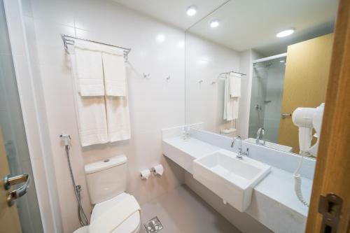 La salle de bains est pourvue de toilettes, d'un lavabo et d'un miroir. dans l'établissement Stop Way Hotel Fortaleza, à Fortaleza