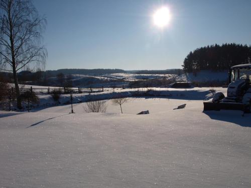 Giławy的住宿－Agroturystyka Giławy，雪地里带拖拉机的雪地