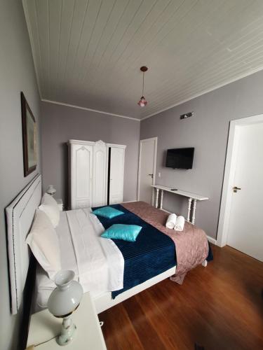 a bedroom with a bed with blue pillows on it at Casa Villa Constanza in Itaipava