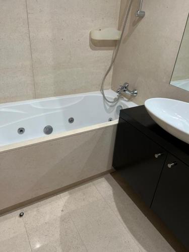 a bathroom with a white tub and a sink at Fozpalace Sweet Home in Portimão