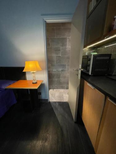 une lampe sur une table dans une chambre avec un four micro-ondes dans l'établissement Paris Marais 75004 Seine River, à Paris
