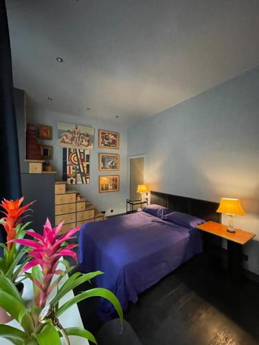a bedroom with a blue bed and a table with a lamp at Paris Marais 75004 Seine River in Paris