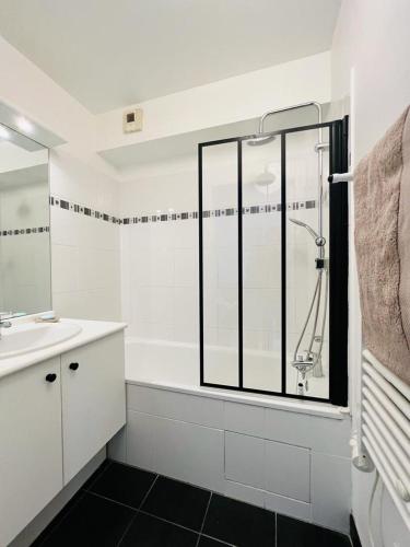 une salle de bain blanche avec une douche et un lavabo dans l'établissement En mode cinéma! Hyper centre ville avec terrasse, à Chartres