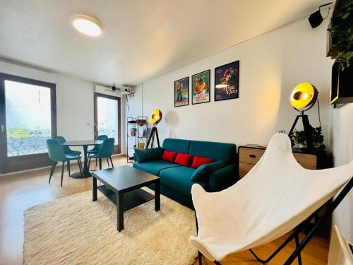 salon z zieloną kanapą i stołem w obiekcie En mode cinéma! Hyper centre ville avec terrasse w mieście Chartres