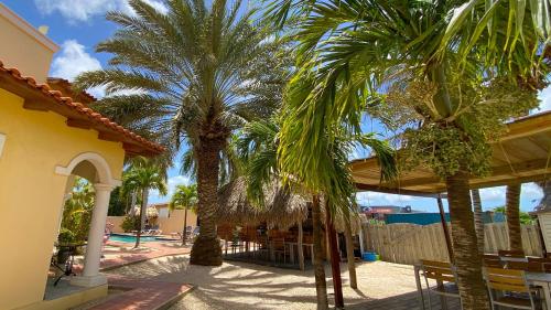 two palm trees in a courtyard with a pool at Sonrisa Boutique Hotel - Adults Only in Kralendijk