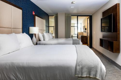 a hotel room with two beds and a flat screen tv at Haywood Park Hotel, an Ascend Collection Hotel in Asheville