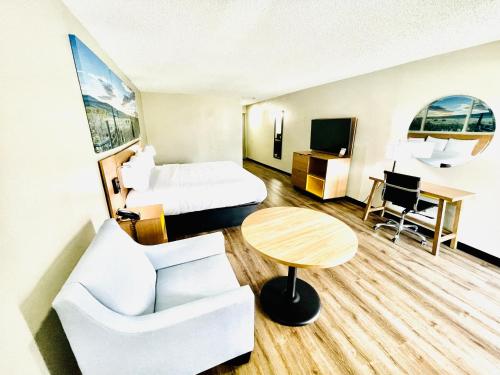 a hotel room with a bed and a table at Days Inn by Wyndham Burleson Ft. Worth in Burleson