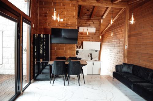 una cucina e una sala da pranzo con tavolo e sedie di Grand Golan Cabins a Buq‘ātā