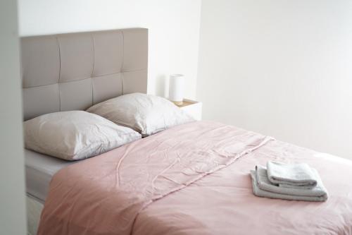 - un lit avec 2 serviettes dans l'établissement Splendide appartement 3 pièces - Parking et Clim, à Valence