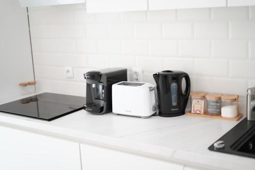 un comptoir de cuisine avec des appareils sur un comptoir blanc dans l'établissement Splendide appartement 3 pièces - Parking et Clim, à Valence