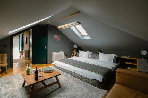 ein Schlafzimmer mit einem großen Bett und einem Tisch in der Unterkunft Mert Boutique Hotel in Korçë