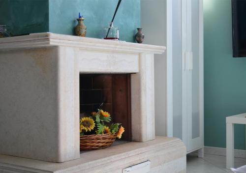 a fireplace with a basket of sunflowers in it at B&B Aquino in Terrazza in Aquino