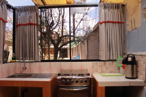 una cocina con fogones y una ventana con un árbol en Bull House en Urubamba