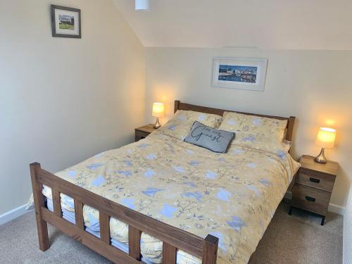 a bed in a bedroom with two lamps on tables at Bracknell Cottage in Freystrop