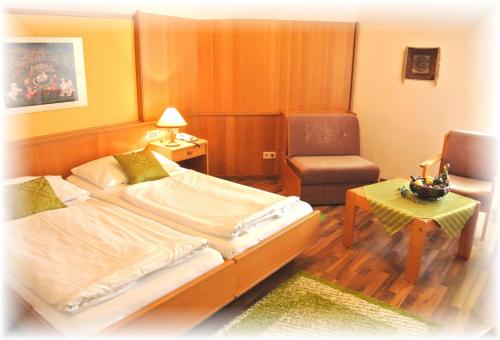 ein Hotelzimmer mit 2 Betten und einem Stuhl in der Unterkunft Parkhotel Neubauer in Sauerbrunn