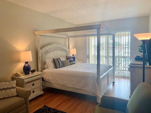 um quarto com uma cama de dossel e uma cadeira em Inn at Camachee Harbor View 22 em Saint Augustine