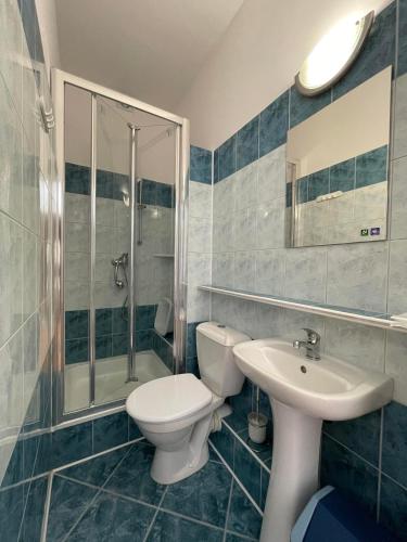 a bathroom with a toilet and a sink and a shower at Pokoje gościnne u Małgosi in Jarosławiec