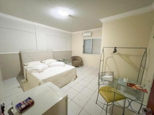 Un dormitorio con una cama, una silla y una mesa de cristal. en Canadá Hotel, en Rio Verde