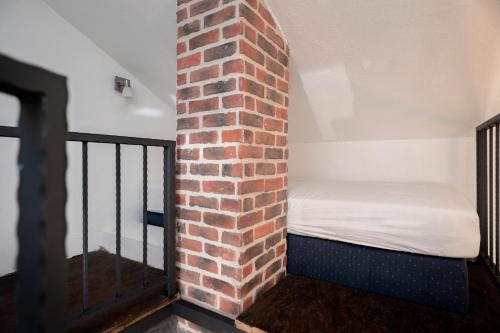 a small room with a brick wall and a bed at Guest House Marinna in Vrboska