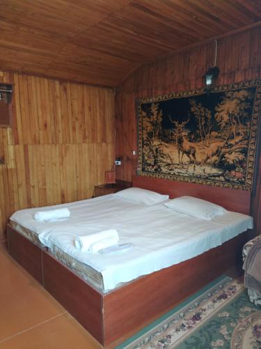 a bedroom with a bed with a tapestry on the wall at IRIS B&B in DEBED CANYON in Alaverdi
