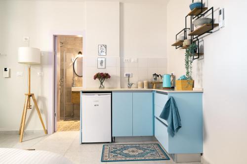 a kitchen with blue cabinets and a sink at PRINCESS of the Dead Sea by CROWN in Neve Zohar