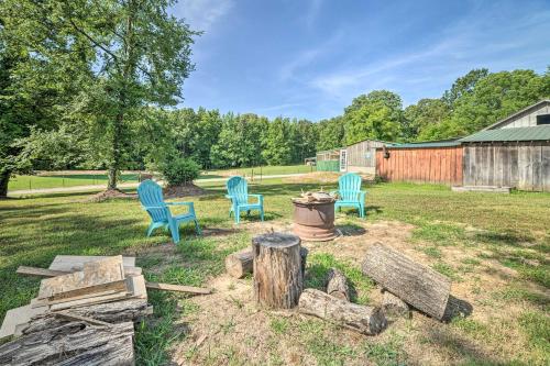 a yard with two blue chairs and a fire hydrant at Charming New Concord Cabin on 50-Acre Farm! in New Concord