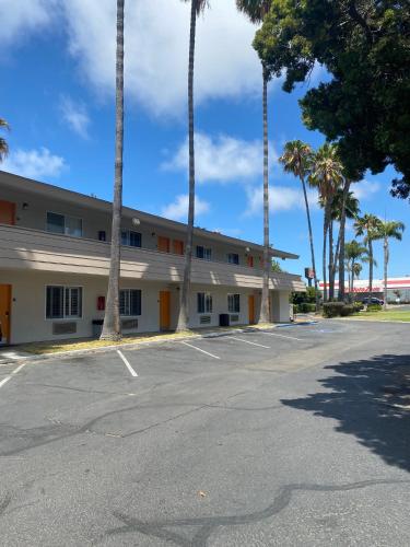 an empty parking lot in front of a building at Hotel Palmeras Chula Vista in Chula Vista