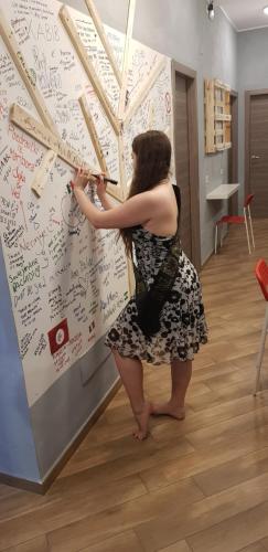 a woman is writing on a wall at Gloria Hostel Milano in Milan