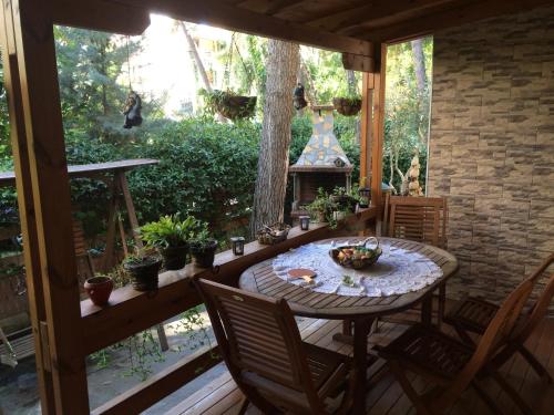 eine Veranda mit einem Tisch, Stühlen und einem Kamin in der Unterkunft Apartment Eurocoli Rezidence in Golem