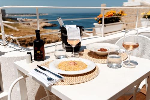 Aquamarea في بولينيانو آ ماري: طاولة مع طبق من الطعام وكؤوس من النبيذ