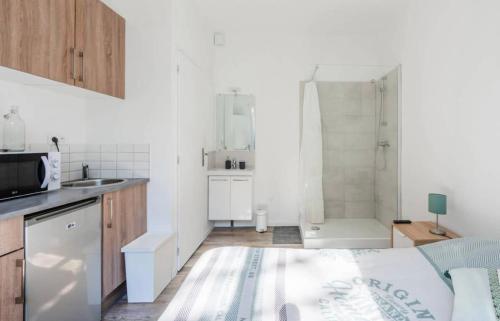 - une petite cuisine blanche avec une douche et un lit dans l'établissement Good mood, à Bordeaux