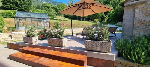a patio with three benches and an umbrella at Casa Rivetta in Valmareno